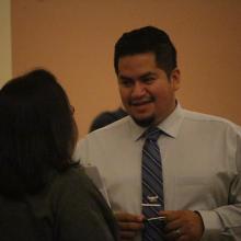 Man in tie holding pen discussing issues